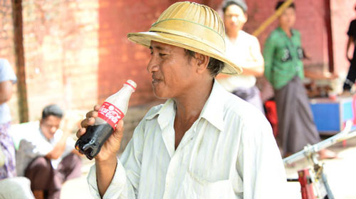 60年ぶりにミャンマーで生産された「コカ・コーラ」を飲む人
